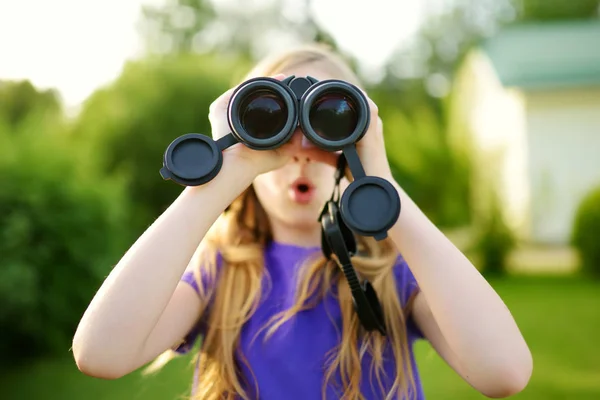 Niña mirando a través de prismáticos — Foto de Stock