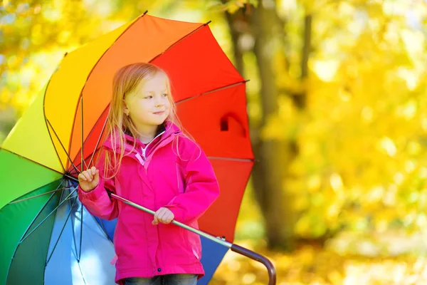 Menina segurando guarda-chuva arco-íris — Fotografia de Stock