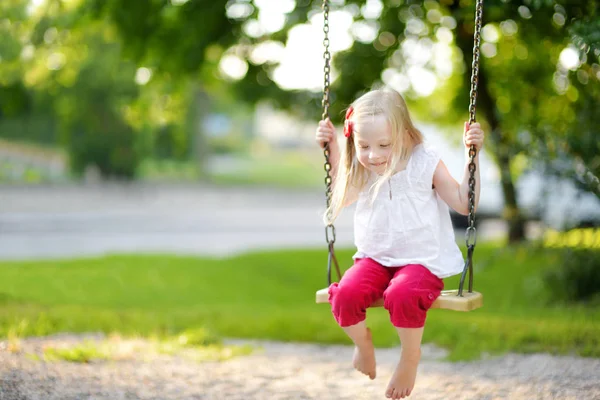 Kleines Mädchen schaukelt auf Spielplatz — Stockfoto