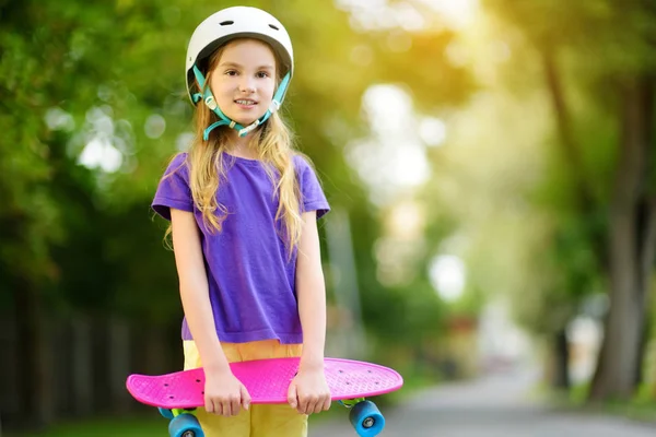 Liten jente som lærer å skate i parken – stockfoto