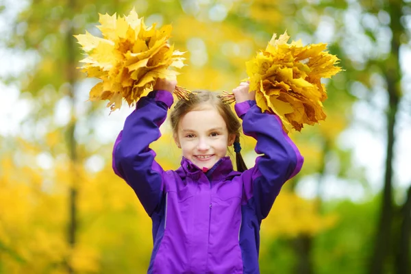 Klein meisje spelen met Herfstbladeren — Stockfoto