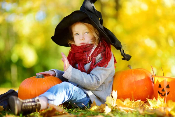 Menina em traje de Halloween com abóboras — Fotografia de Stock