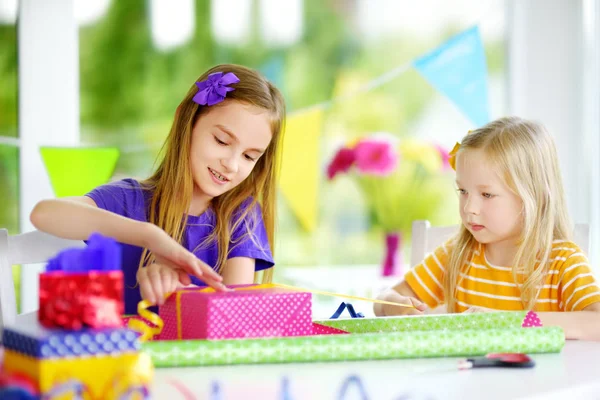 Hermanas pequeñas envolviendo regalos — Foto de Stock