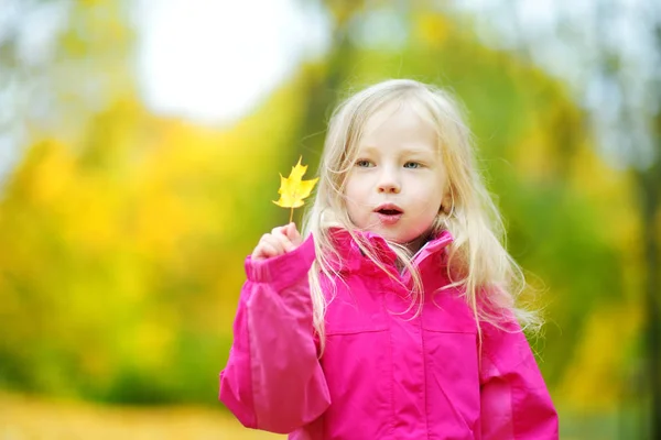 Bambina che gioca con la foglia d'autunno — Foto Stock
