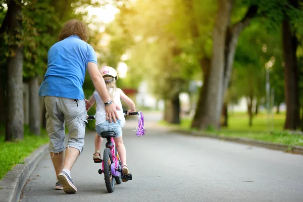 Babası kızına bisiklet sürmeyi öğretiyor. — Stok fotoğraf