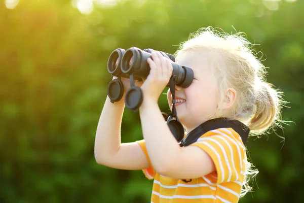 Liten flicka tittar genom kikare — Stockfoto