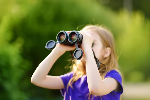 Kleines Mädchen schaut durch Ferngläser — Stockfoto