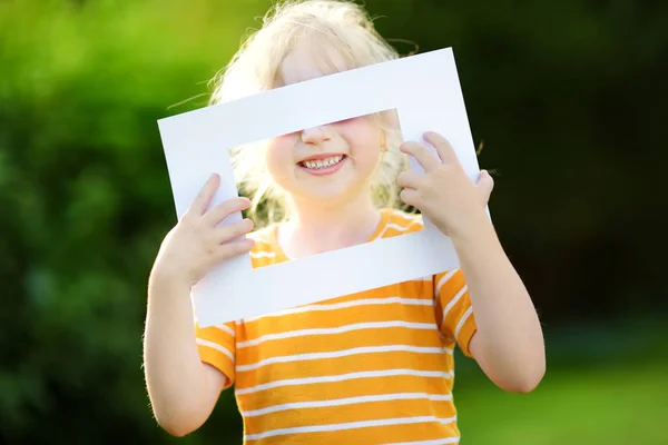 Niña sosteniendo marco blanco — Foto de Stock