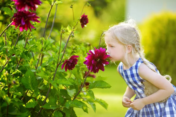 Meisje snuiven op paarse bloemen — Stockfoto