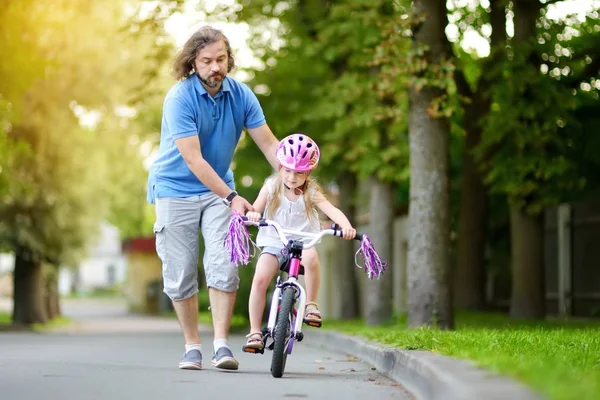 Padre enseñando a su hija a montar en bicicleta —  Fotos de Stock