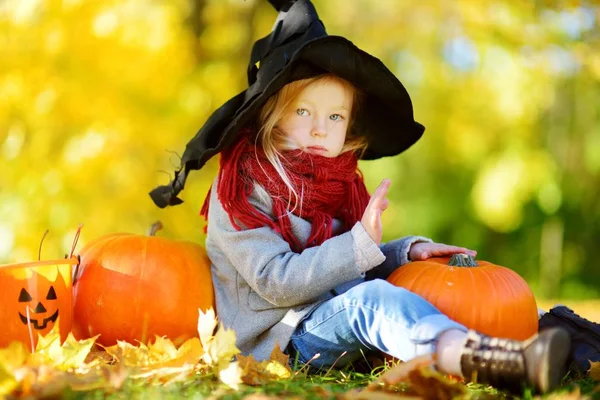 Menina em traje de Halloween com abóboras — Fotografia de Stock