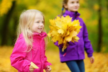 küçük kız sonbahar yaprakları ile oynamak 