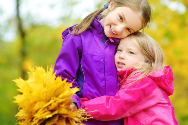 küçük kız sonbahar yaprakları ile oynamak 