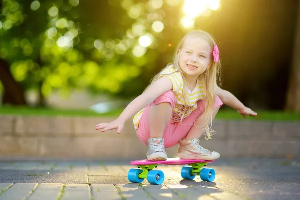 küçük kız parkta kaykay için öğrenme