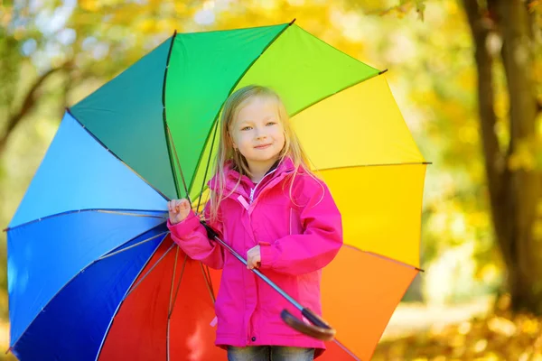 little girl holding rainbow umbrella