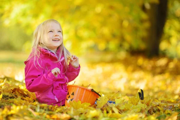 Bambina che gioca con foglie autunnali — Foto Stock