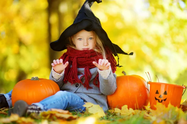 Menina em traje de Halloween com abóboras — Fotografia de Stock