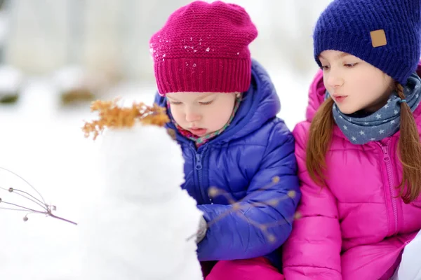 两个小女孩做雪人 — 图库照片