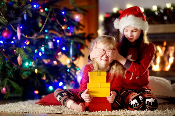 Little sisters hediyeler Noel ağacı yakınındaki — Stok fotoğraf