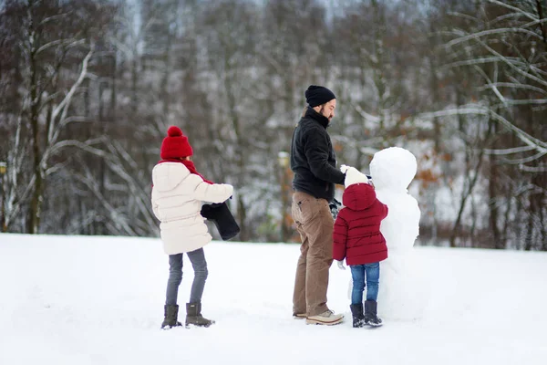 Små flickor med Fadern att göra snögubbe — Stockfoto