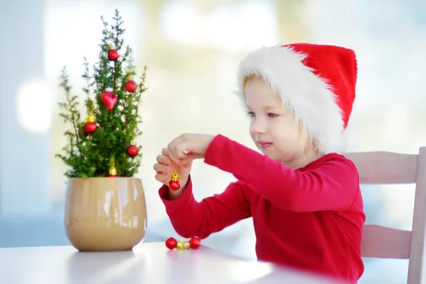 Lány díszítő kis karácsonyfa — Stock Fotó
