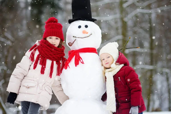 两个小女孩与雪人 — 图库照片
