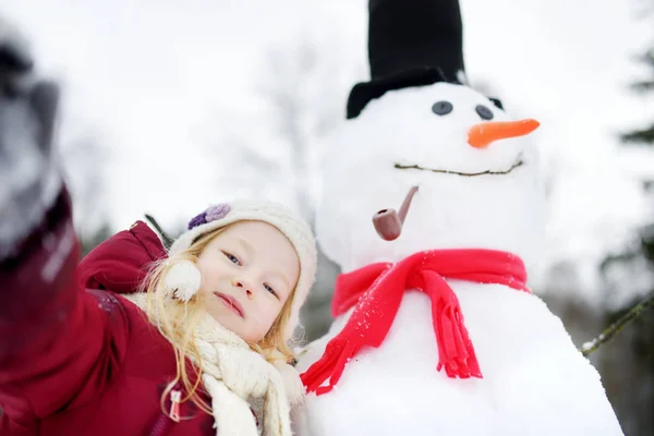 Menina fazendo boneco de neve — Fotografia de Stock