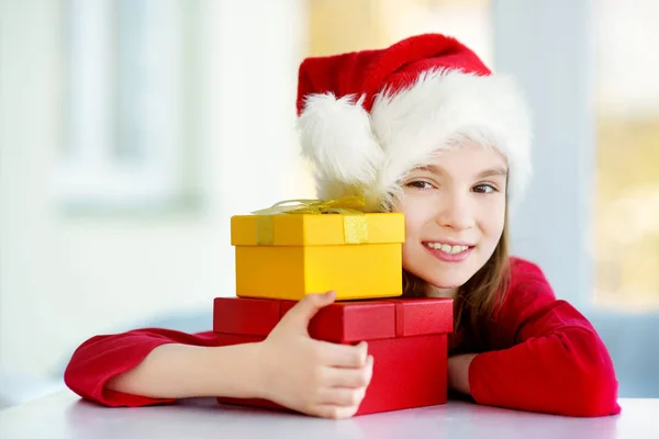 Дівчина в капелюсі Санта з подарунками — стокове фото