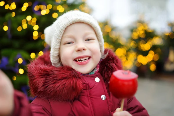 Meisje eten rode appel snoep — Stockfoto