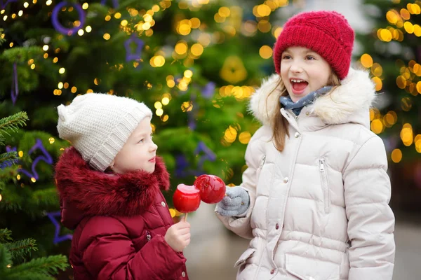 Kleine zusters op kerstmarkt — Stockfoto