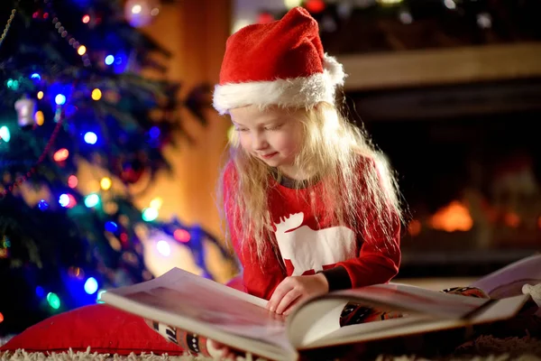 Mała dziewczynka czytanie książki na Boże Narodzenie — Zdjęcie stockowe