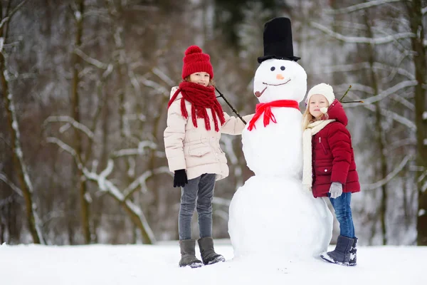 Deux petites filles avec bonhomme de neige — Photo