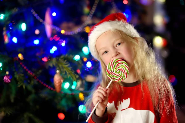 Meisje eten lollipop op Kerstmis — Stockfoto