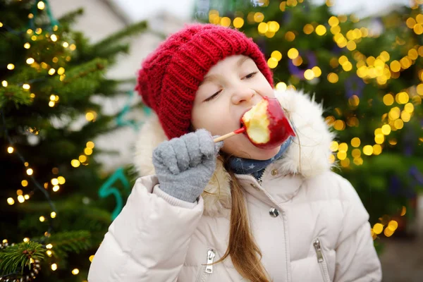 Ragazza mangiare caramelle di mele rosse — Foto Stock