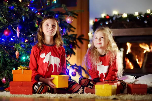 Little sisters med gåvor nära julgran — Stockfoto
