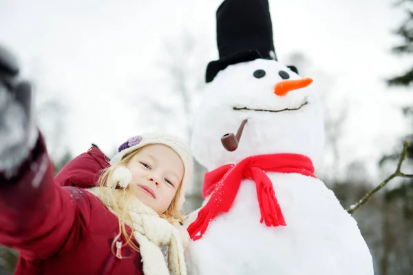 Menina fazendo boneco de neve — Fotografia de Stock