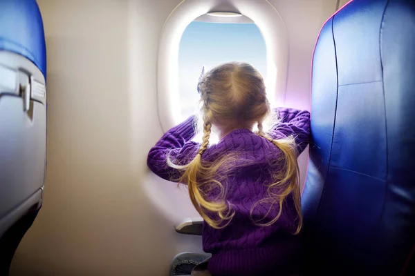 Adorable little girl traveling by an airplane — Stock Photo, Image