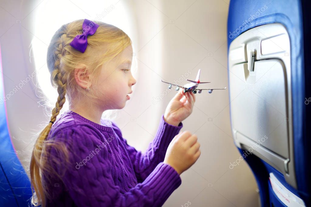 Adorable little girl traveling by an airplane