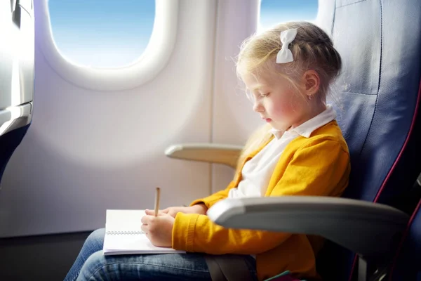 Очаровательная маленькая девочка, путешествующая на самолёте — стоковое фото
