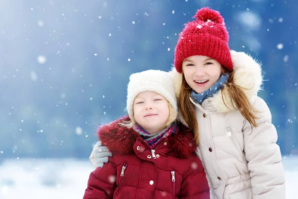 Beautiful sisters playing in a snow. — Stock Photo, Image