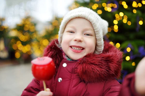 Meisje eten apple bedekt met suiker — Stockfoto