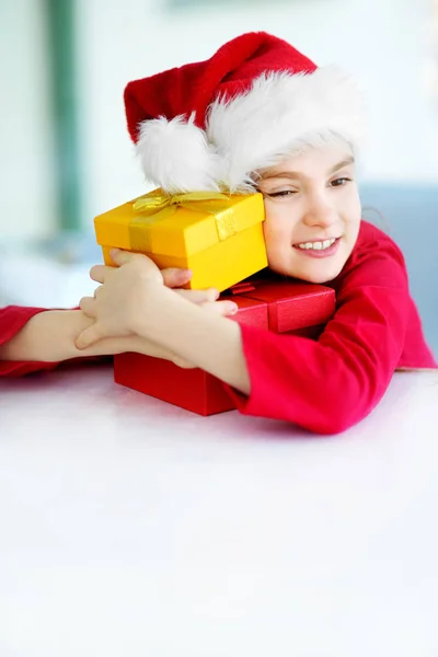 Κοπέλα φορώντας καπέλο Santa άνοιγμα συσκευασία δώρου — Φωτογραφία Αρχείου
