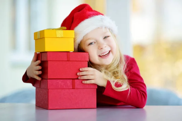 Fille portant le chapeau de Père Noël avec des boîtes cadeaux — Photo