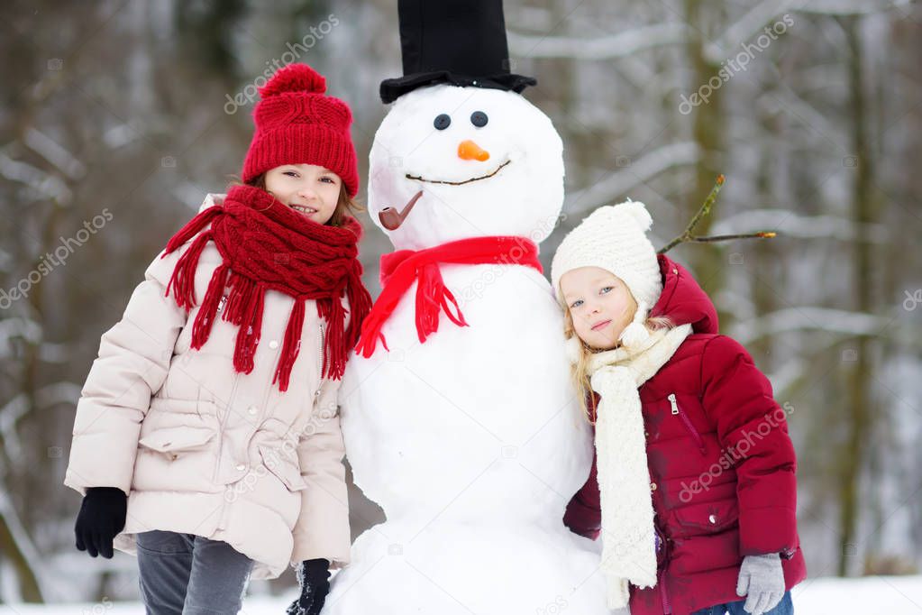  little girls building a snowman