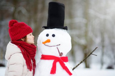 Sevimli küçük kız bir kardan adam bina