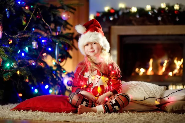 Γιορτάζοντας Χριστούγεννα στο σπίτι το μικρό κορίτσι. — Φωτογραφία Αρχείου