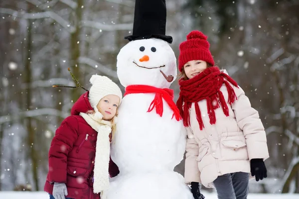Kleine meisjes sneeuwpop bouwen — Stockfoto