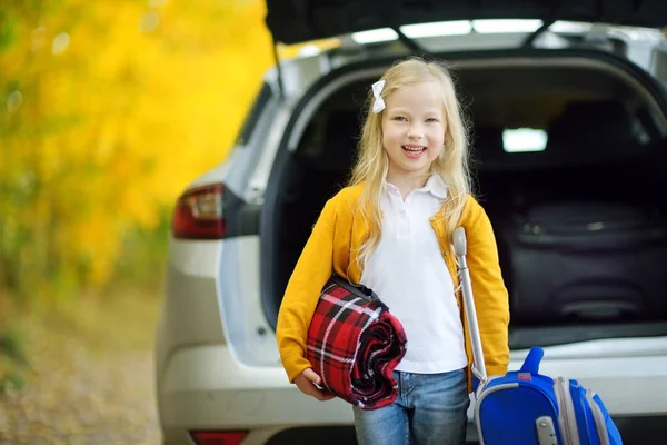 Meisje met koffer in de buurt van auto — Stockfoto