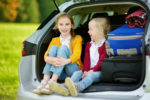 Pienet tytöt istuvat auton takakontissa — kuvapankkivalokuva