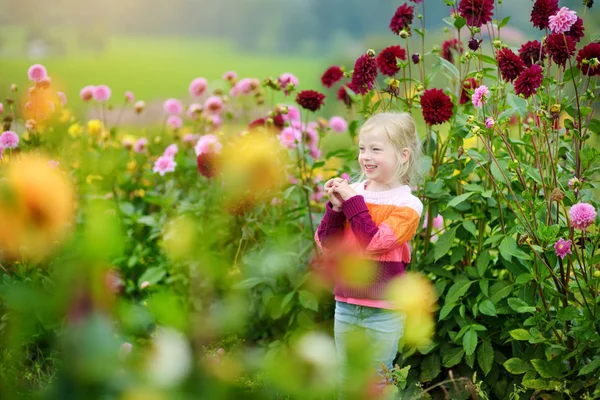 Bambina che annusa fiori viola — Foto Stock